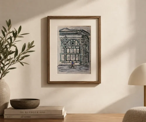 Framed "The Traveller" oil painting by Anahit Samvelyan hung on a neutral wall above a wooden table and minimalist decor.